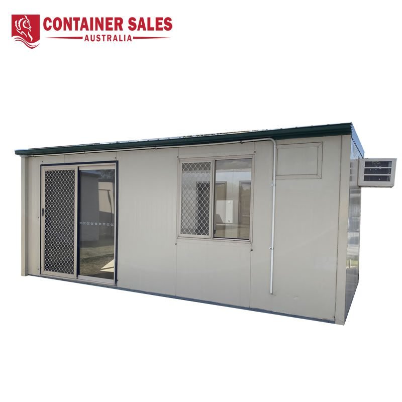 Site Accommodation Container For Sale 2 Beige modular container building with a sliding glass door, a window with a security grille, and a wall-mounted air conditioner; Container Sales Australia logo at the top left.