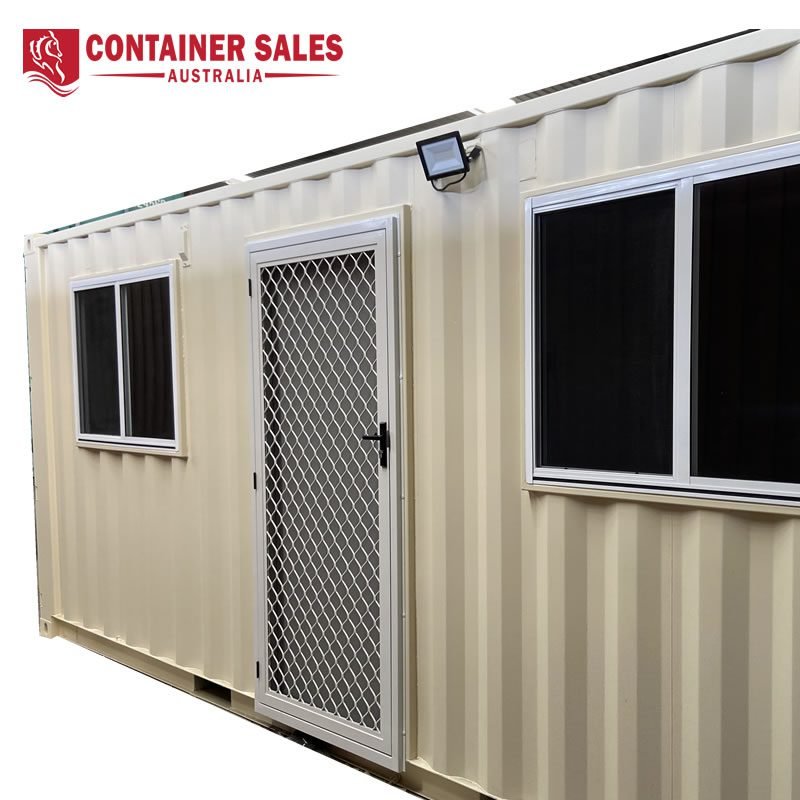 Site Accommodation Container For Sale 3 Beige shipping container with a mesh-screen door and two side windows, branded Container Sales Australia in the top corner.